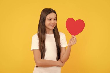 Aşk hediyesi. Aşk hediyeli gülümseyen çocuk. Tatlım. Sevgililer günü indirimi. Kalbi olan bir çocuğun portresi. Sevgililer günün kutlu olsun. Sevgilim olur musun? Sarı arka plandaki genç kız..