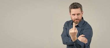 Flipping someone off. Bearded man show middle finger upwards. Obscene hand gesture, fuck you. Man face portrait, banner with copy space