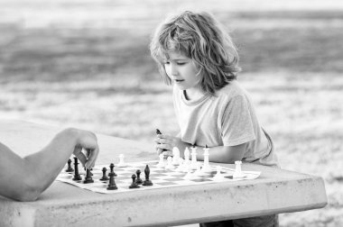 Çocuk babasıyla parkta satranç oynuyor, çocukluk arkadaşı..