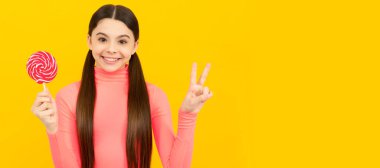 Sarı zemin üzerinde lolipop şekeri olan mutlu çocuk, huzur.