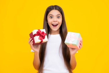 Emotional teenager child hold gift on birthday. Funny kid girl holding gift boxes celebrating happy New Year or Christmas. Excited teenager, glad amazed and overjoyed emotions