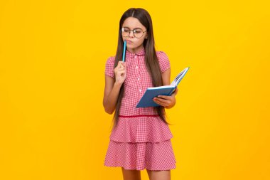 Genç kız öğrenci kitapları, not defterleri, sarı arka planda izole edilmiş, kopyalama alanı. Okula dönüş, gençlik yaşam tarzı, eğitim ve bilgi. Düşünen zeki genç kız