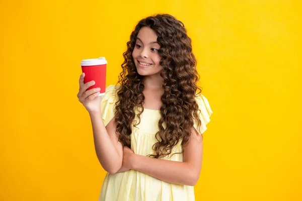 stock image Teenage girl with take away cup of cappuccino coffee or tea. Child with takeaway cup on yellow background, morning drink beverage. Happy teenager portrait. Smiling girl