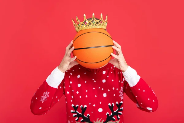クラウンの冬の男はバスケットボールボールを保持します ポートレートのクリスマスサンタ男上の赤いスタジオの背景 — ストック写真