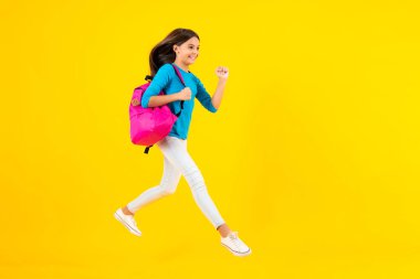 Sırt çantalı okul çocuğu. Tecrit edilmiş genç bir öğrenci. Öğrenme ve bilgi. Git çalış. Koş ve atla. Eğitim konsepti. Mutlu ergen portresi. Gülümseyen kız