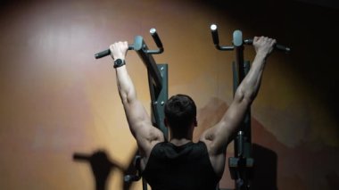 Sporcu spor salonunda barfiks egzersizi yapar. Spor salonunda barfiks çeken bir sporcunun arka görüntüsü. Sporcu spor salonunda spor barfiks ekipmanıyla antrenman yapar..