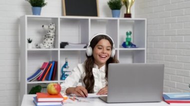 Kulaklıklı neşeli çocuk laptopla bitirme dersi alıyor, Eylül.