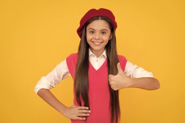 Başparmağını kaldır. Okula dönüyorum. Bereli neşeli çocuk. Gülümseyen çocuğun mükemmel bir tarzı var. Ergen güzellik. Gençlik ve gençlik. Sıradan moda. Mutlu Fransız genç kız baş parmağını kaldırıyor. çocukluk mutluluğu.