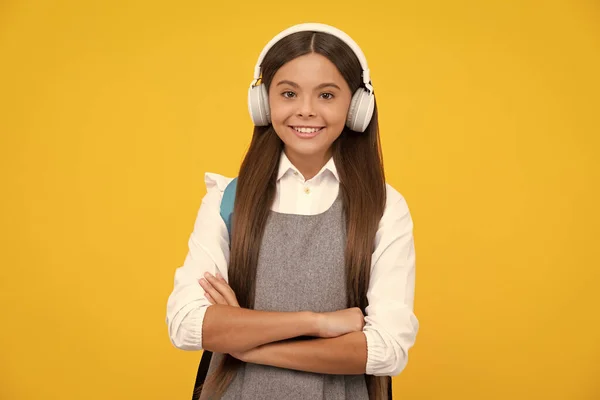 女学生 戴耳机的女学生 背景是黄色的隔离工作室 学校和音乐教育的概念 回学校去快乐的女孩脸 积极的微笑的情绪 — 图库照片
