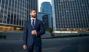 charismatic businessperson in businesslike suit outside the office, copy space, success.