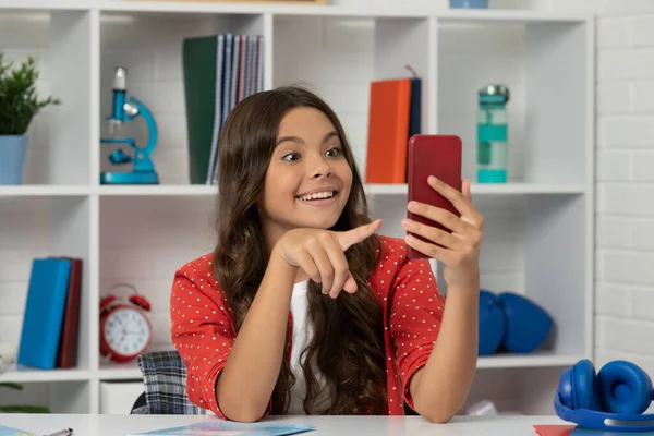用手机制作视频的少女惊讶地指着自己 手机是内容制造者 — 图库照片