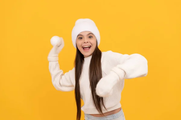 冬の帽子と手袋の子供は黄色の背景に雪玉で遊ぶ冬 — ストック写真