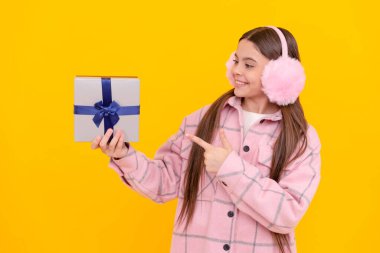 Mutlu çocuk gülümseyip parmağını şimdiki sarı arka plana gösteriyor, hediye..