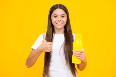 Plastik şişeden su içen genç bir kız çocuğu izole bir arka planda, kopyalama alanı. Çocuk bakım vücut sıvısı. Aktif eğlence ve su dengesi. Mutlu ergen portresi. Gülümseyen kız