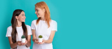 Anne ve kız çocuk afişi, kopyalama alanı, izole edilmiş arka plan. Mutlu kadın anne ve kız çocuk gülüşü ellerinde mavi arka plan, yetiştirme