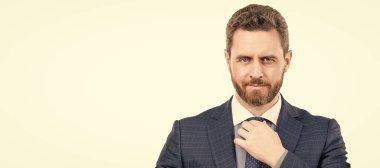 Portrait of professional man businessman with serious face adjusting necktie in formal suit, boss. Man face portrait, banner with copy space. Business man in suit, isolated studio background