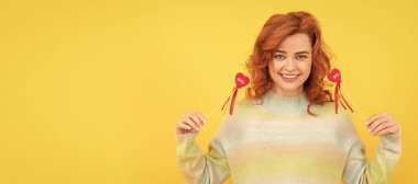 İzole edilmiş yüz portresi, fotokopi alanı olan pankart. Kırmızı kalpli mutlu kızıl kadın sarı arka plana yapışıyor. Sevgililer Günü