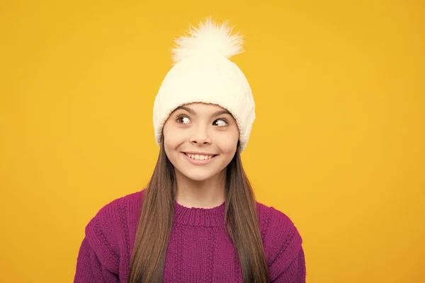 美しい冬の子供の肖像画 ティーン女の子Posingとともに冬のセーターとニット帽上の黄色の背景 — ストック写真