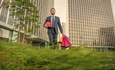 Sevgilim olur musun? Boks günü. Hediyeli kutusu olan yakışıklı bir adam. Erkek doğum günü hediyesi taşır. Adam alışveriş torbalarını tutuyor. Erkekler günü. Paketleri olan mutlu bir iş adamı. Satış ve indirim. Ona sürpriz yap..