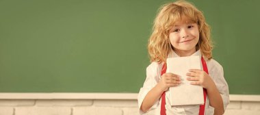 Tahtadaki öğrenci çocuk, afiş fotokopi alanı. Okulda papyon takan neşeli çocuk ders çalışıyor. Not defteri, kopya alanı, bilgelik gösteriyor..