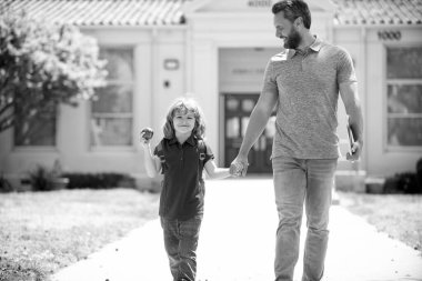 Öğretmeni elma tutan inek. Eğitim. Okuldaki ilk günüm. Baba ve oğul okuldan dönüyorlar. Mutlu aile değerleri. Çocukluk ve ebeveynlik. Anne babası birinci sınıfta küçük çocuğu yönetiyor..