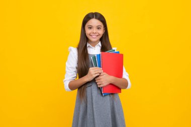 Genç kız öğrenci kitapları, not defterleri, sarı arka planda izole edilmiş, kopyalama alanı. Okula dönüş, gençlik yaşam tarzı, eğitim ve bilgi. Mutlu kız yüzü, pozitif ve gülümseyen duygular