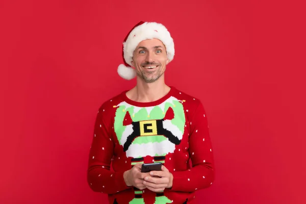 산타가 전화로 수다떨고 크리스마스 스웨터를 남자와 배경의 모자를 — 스톡 사진