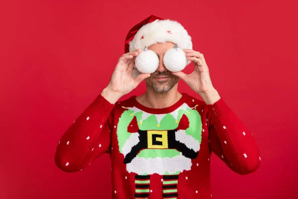 크리스마스 스웨터입은 남자와 배경의 모자쓴 크리스마스 공놀이를 — 스톡 사진