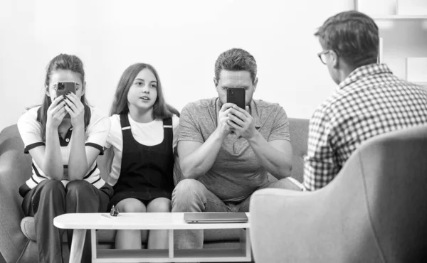 stock image parents with kid talk to social worker. phone addicted mom dad and daughter. life insurance and adoption. parent-teacher meeting. father mother and child at psychologist session. family therapy.