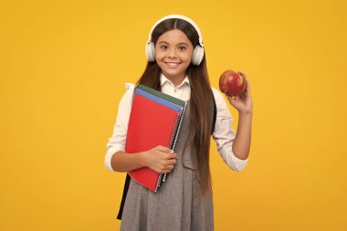 School teen girl in headphones and books, copy space, back to school. Happy girl face, positive and smiling emotions