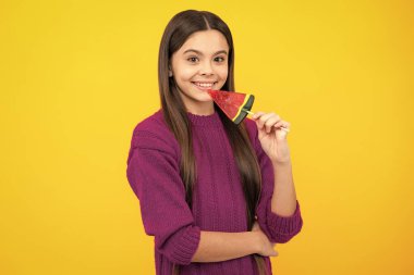 Teen girl hold lollipop caramel on yellow background, candy shop. Teenager with sweets suckers