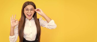 Okul üniformalı ve görüş koruması için gözlüklü bir çocuk el sallıyor. Çocuk yüzü, yatay poster, izole edilmiş genç kız portresi, fotokopi alanı olan pankart