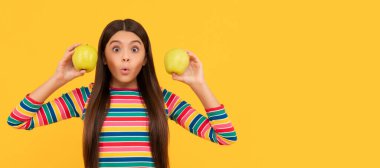 Günde elma yeterli değil. Elma tutan sürpriz kız. Sağlıklı olmak için elma yiyorum. Elmalı çocuk portresi, yatay poster. Kopyalama alanı olan başlık