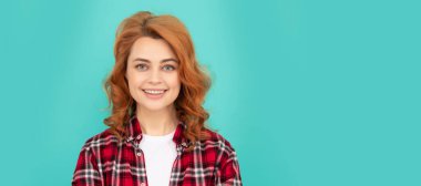 İzole edilmiş bir yüz portresi, kopyalanmış bir afiş. Kıvırcık saçlı neşeli bir bayan. Güzellik ve moda. Kareli gömlekli kadın model.