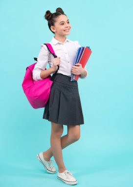 Okula dönelim. Öğrenci kızın elinde mavi izole edilmiş stüdyo geçmişi hakkında bir kitap var. Okul ve eğitim kavramı. Okul üniformalı ergen kız. Mutlu ergen, pozitif ve gülümseyen liseli