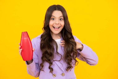 Şampuan kremi kullanan bir çocuk. Günlük kozmetik bakım. 12, 13, 14 yaşlarındaki ergen çocuğun elinde saç ve cilt bakımı şişesi var. Güzellik sağlığı ve kozmetik ürünleri. Mutlu genç