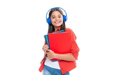 Back to school. Schoolgirl student in headphones with school bag backpack hold book on isolated studio background. School and education concept. Portrait of happy smiling teenage child girl