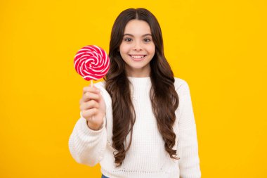 Heyecanlı bir yüz. Şekerli lolipopu olan genç bir kız, 12, 13, 14 yaşlarında şeker yiyip şeker yiyen mutlu bir çocuk. Mutlu yüz, pozitif ve gülümseyen genç kız duyguları