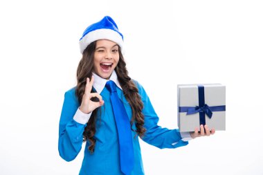 Yeni yıl ya da Noel hediyesi. Heyecanlı bir yüz. Stüdyonun arka planında hediye kutusu olan çocuk. Çocukların doğum günü hediyesi. Şaşırtıcı bir ifade, neşeli ve mutlu.