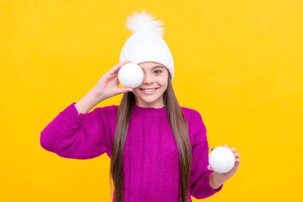带着装饰球的孩子一个积极的少女拿着黄色背景的雪球 圣诞节假期装饰 童年的概念 快乐的圣诞节 新年快乐 戴着冬帽的快乐孩子 — 图库照片