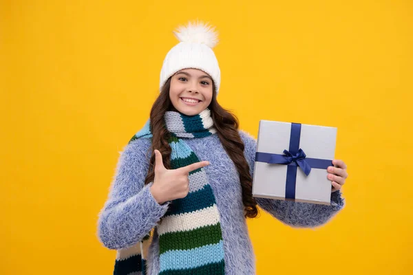 Happy girl face, positive and smiling emotions. Funny kid girl in winter wear holding gift boxes celebrating happy New Year or Christmas. Winter holiday