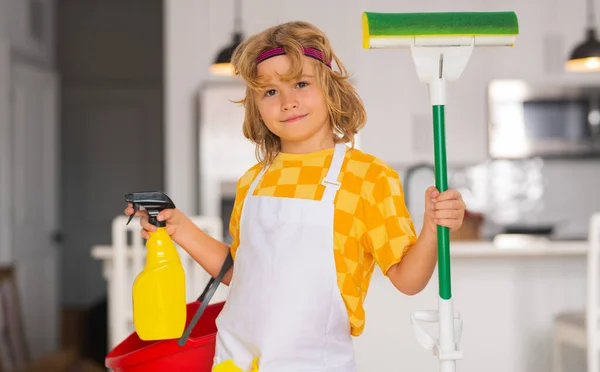 Little kid cleaning at home. Child doing housework having fun. Portrait of child housekeeper with wet flat mop on kitchen interior background