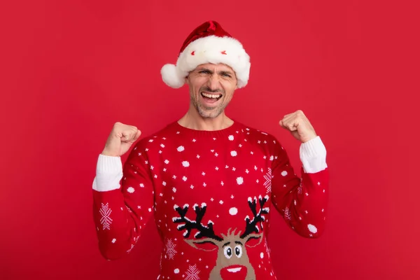感情上的圣诞老人穿着节日毛衣 头戴圣诞帽的男人 背景是工作室 圣诞特价或冬季特价 — 图库照片
