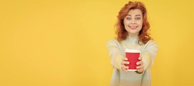 take this. happy red haired woman drink coffee. take away beverage. cheerful girl drinking tea. Woman isolated face portrait, banner with copy space