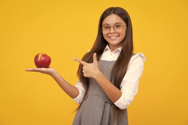 Fresh apple. Teenager girl hold apples on yellow isolated studio background. Child nutrition. Happy girl face, positive and smiling emotions