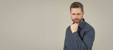 Sakal burada kalacak. Tıraşsız bir adam sakallı, gri arkaplana dokunur. İnsan yüzü portresi, kopyalama alanı olan pankart