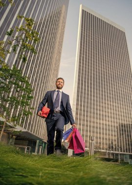 boxing day. handsome man with present box. smiling entrepreneur carry birthday gift. guy hold shopping bags. mens day. happy businessman with packages. sale and discount. surprise for her.