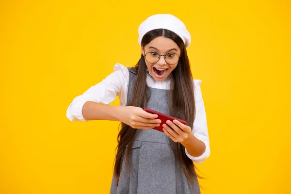 소녀가 핸드폰을 있습니다 휴대폰 사용하는 귀여운 소녀의 사진밝고 노란색 배경에 — 스톡 사진