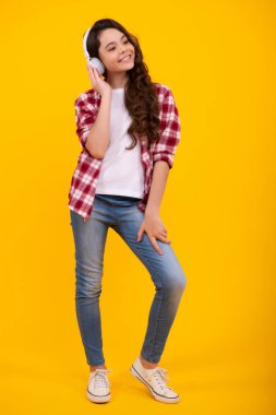 12, 13, 14 yaşlarında komik bir kız. Kulaklıklı müzik dinliyor. Kulaklıklı genç kız kulaklıkla şarkı dinliyor. Mutlu ergen, pozitif ve gülümseyen genç kız duyguları