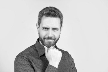 Yakışıklı, orta yaşlı, sakallı ve şık saç kesimi olan gri gömlekli, berber dükkanlı, fotokopi çeken bir adam..